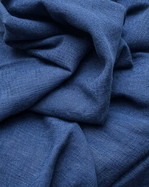 Mantel de lino Porto en tono azul profundo sobre mesa